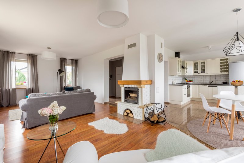 salón con suelo de madera y chimenea